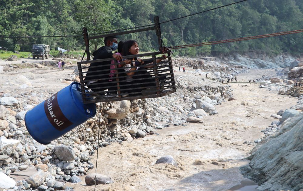 मेची राजमार्गअन्तर्गत पाँचथरको हेवा खोलामा रहेको मोटरेवल पुल पहिरोले क्षति पुराएपछि तुइनबाट खोला तर्दै सर्वसाधारण ।